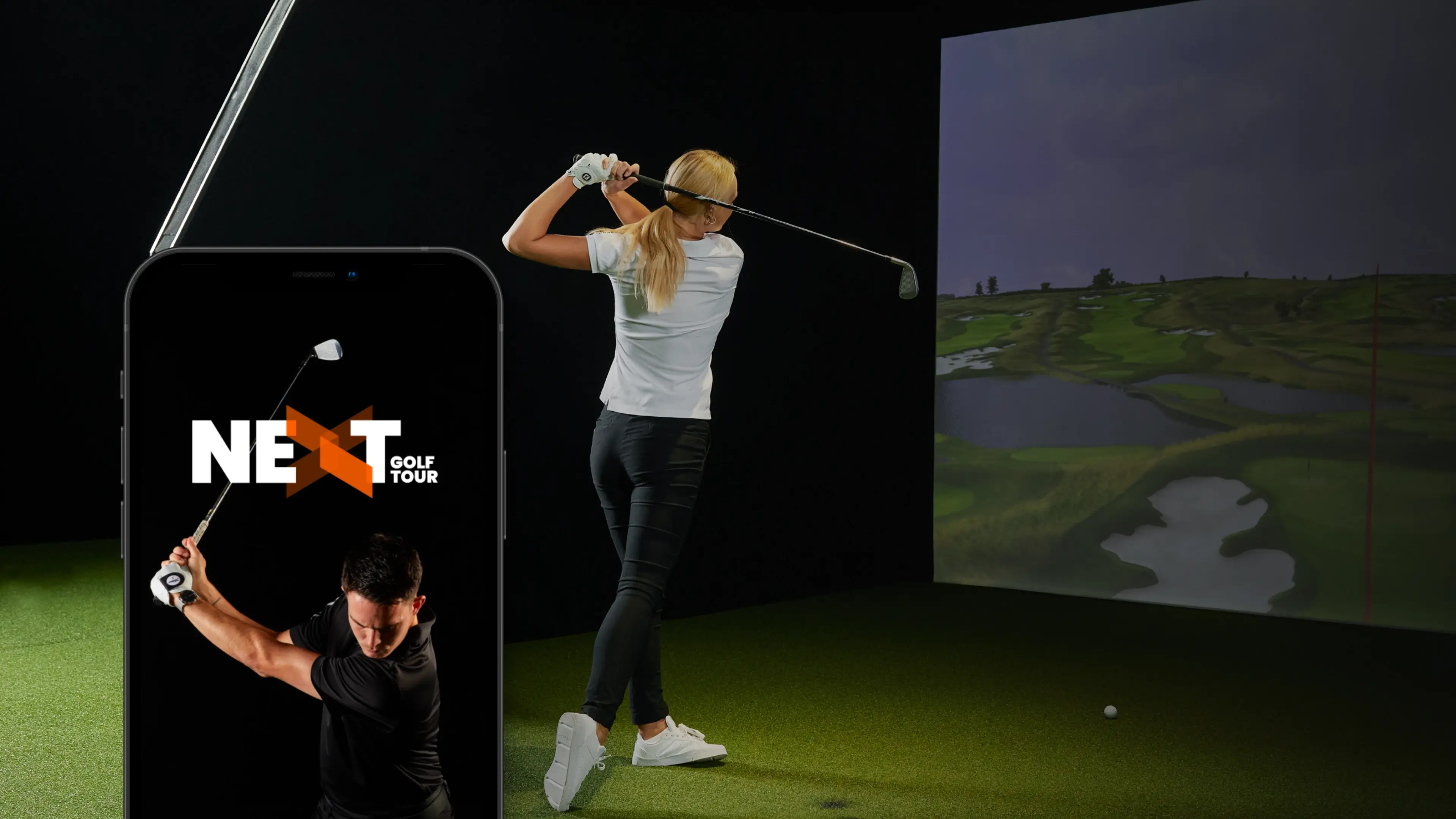 Woman swinging a golf club indoors on a simulator, with a smartphone displaying "Next Golf Tour" in the foreground.